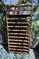 Full front view of tall wooden wine rack showing all shelves