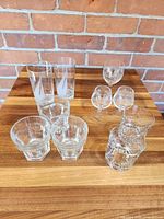 Group shot of all ten clear glass pieces on wooden surface