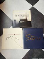 Three LP jackets laid out on checkered floor