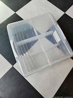 angled view of IRIS clear media box showing lid, side handle, and interior dividers