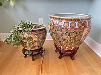 Both porcelain planters on their wood stands, jade plant visible