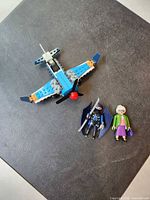 Full view of LEGO airplane with two Playmobil figures