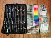 Open zip case with Prismacolor markers, Sharpie and Micron pens laid beside, Staedtler fineliner packs shown