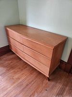 Front and side view of dresser showing veneer, integrated pulls, tapered legs