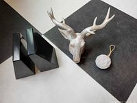Group shot: pair of black marble bookends, plaster elk head, concrete ornament