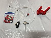 All items laid out: NukaTap filler with tubing, hand capper, washer, bag of caps