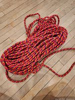 Coiled red nylon rope on wood floor
