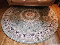 Full view of round green oriental rug beneath sofa showing overall size and pattern