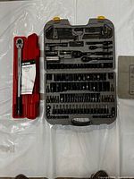 Overall view of torque wrench in red case and socket set in grey case