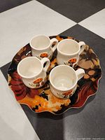 Group view of four mushroom mugs on floral tray
