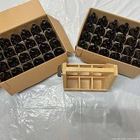 Cardboard boxes with 48 amber stubby bottles and empty wooden crate