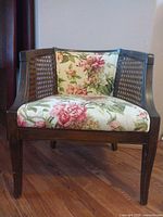 Front view of wooden cane chair with floral cushions