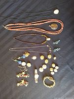 Full lot overview showing necklaces, earrings, watch, bracelet, buttons