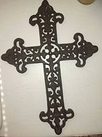 Large ornate cast iron cross with scrollwork