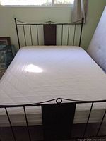 Full view of bed showing headboard, mattress and adjacent items