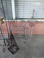Group view showing half-round rack, white candle holder, pyramid trellis, part of vertical stand