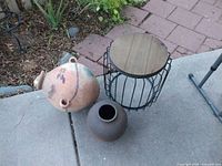 Wood-top metal side table, large terracotta pot, small dark clay pot on patio