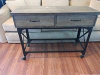 Front view of cart showing two drawers, mesh shelf, and caster wheels