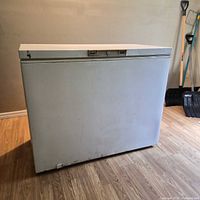 Front view of white chest freezer showing dents and scratches