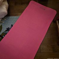 Top view of full-length pink yoga mat laid flat