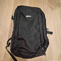 Front view of MEC black backpack showing logo, zippered front panel and overall condition