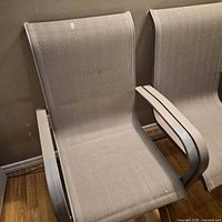 Close view of two chairs showing fabric pattern, armrest design