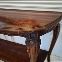 Top corner and apron detail showing scalloped edge, finish tone and wood grain