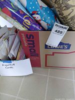 Box with cards and rolls of gift wrap