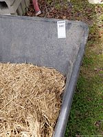 Interior of black poly tub showing straw debris