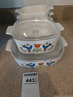 Front view showing two square casseroles with lids stacked and three oval bakers behind