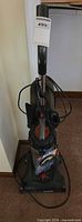 Full view of Eureka upright vacuum with hose and tools attached
