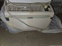 Front and top view of Haier window air conditioner showing grille, controls, power cord