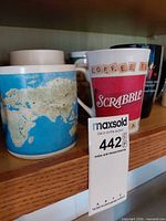 World map mug, Scrabble mug and additional mugs on shelf
