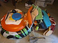 Overhead view showing inflatable tube, life jackets, cushions, paddles, pool noodles, boat anchor and small accessories