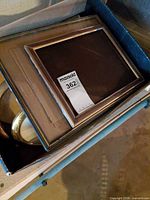 Overview of bin containing multiple gold and wood frames with mirror