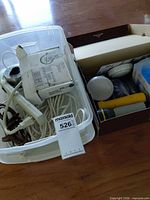 overview of tub and box showing cords, power strip, bulbs, flashlight
