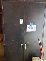 Front view of closed black Lyon cabinet showing dual handles and lock