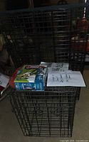 Stacked folded metal wire crates with grooming kit box and papers on top