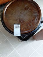 Stack of pans showing round copper-patina pan atop black speckled roaster