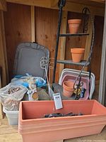 Overall lot with planter trough, metal stand, pots, bin of stones and decorative rocks