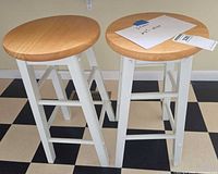 Pair of bar stools front view showing seats and white legs
