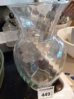 Textured clear glass vase with checkered pattern next to additional glass vessels