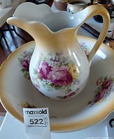 Pitcher nested in matching wash bowl showing floral transfers and gradient rim