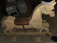 Side view of wooden glider rocking horse showing saddle, tail, base and bolt hardware