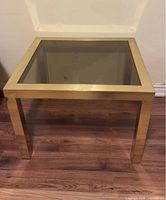 Full view of brass frame side table with smoked glass top