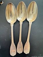 Three sterling silver spoons, front view