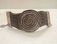 Front view showing leather strands and spiral shield