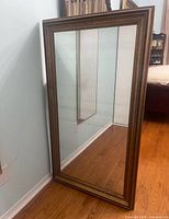 Front view of gold framed full length mirror
