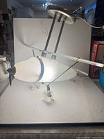Full view of Hampton Bay airplane pendant light showing shape, wings, wheels, rods and canopy