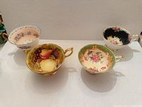 Four assorted high-end teacups displayed upright